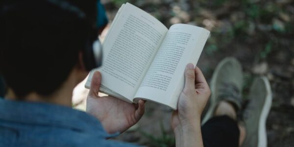 crop man in headphones reading book