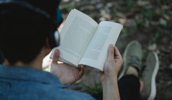 crop man in headphones reading book