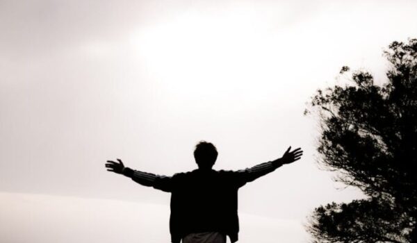 silhouette of a person standing with arms outstretched